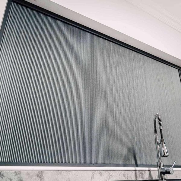 BlindScreen® cellular blackout blind fully closed over a kitchen window, showing the slim cassette and pleated honeycomb fabric