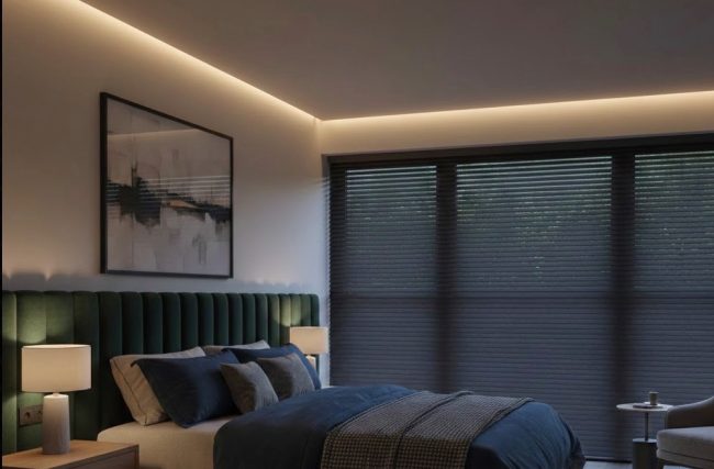 Bedroom with plantation shutters and integrated blackout blind — layered window treatment for noise dampening and room-darkening in a Leicestershire home.