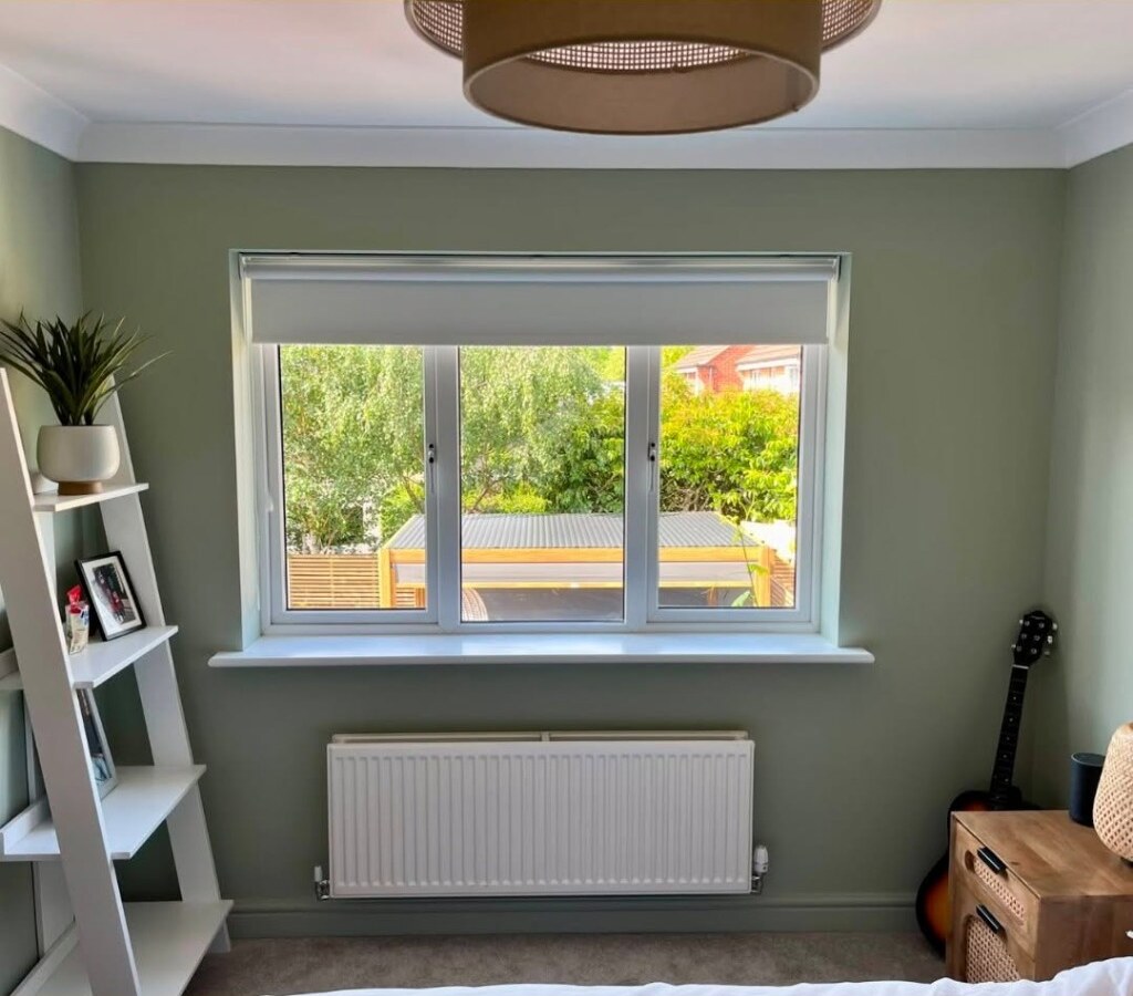 Bedroom window in Lowdham before shutters — white roller blind partly lowered over a three-pane casement
