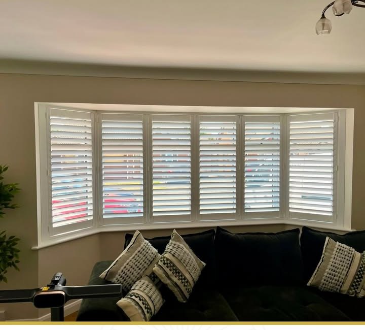 Wider bay window fitted with white plantation shutters in a Leicestershire home