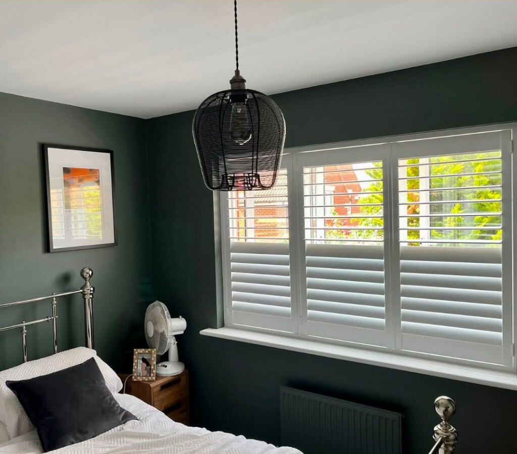 Close view of the bedroom shutter install — top louvres open, lower louvres closed for privacy