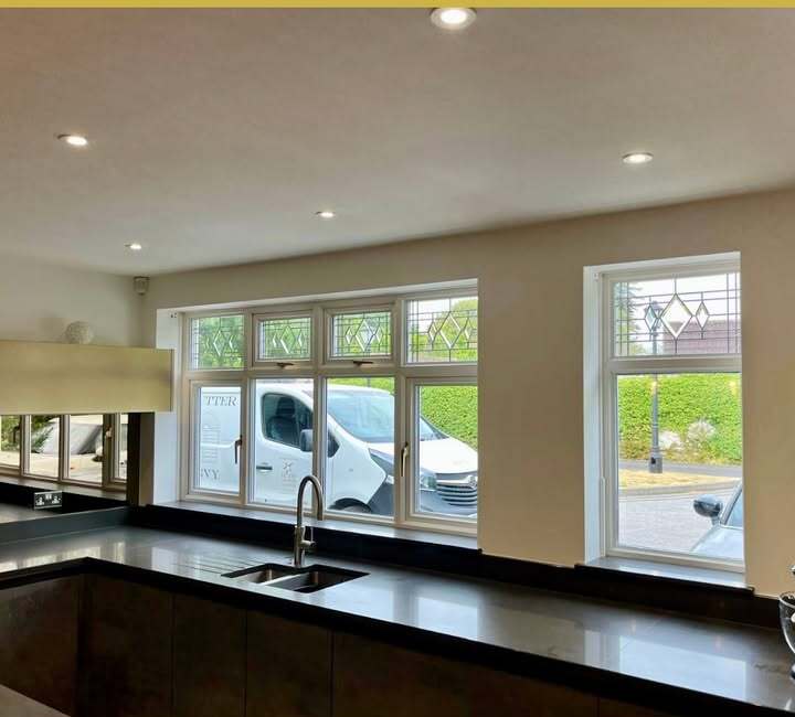 Cossington kitchen windows before shutter installation — two openings above a dark stone worktop and stainless sink