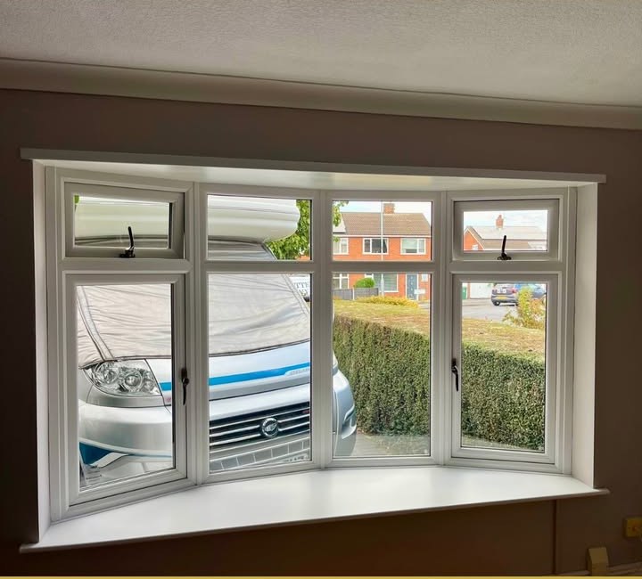 Loughborough bay window before shutters — white four-section uPVC bay looking onto the street